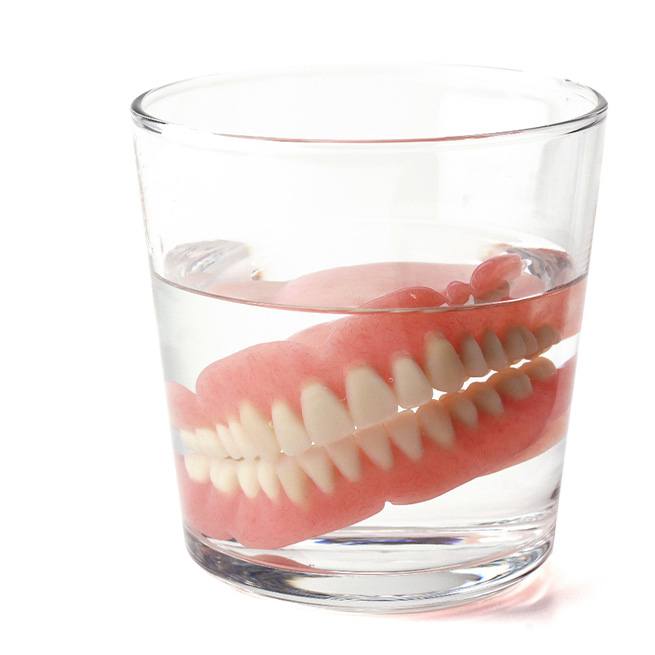 Full dentures in glass with clear liquid