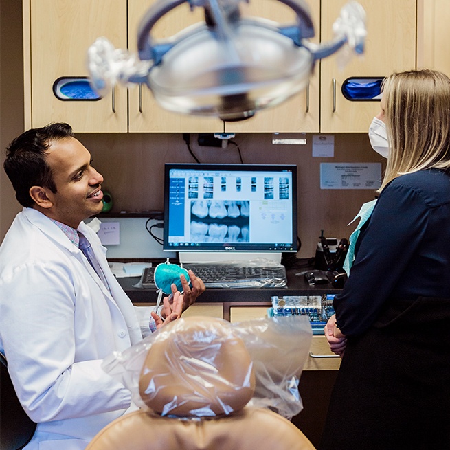 Dentist and dental team member looking at digital x-rays