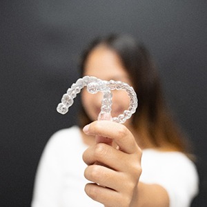 Closeup of female patient holding clear aligners in Burien