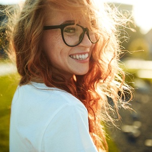 smiling woman after investing cosmetic dentistry in Burien