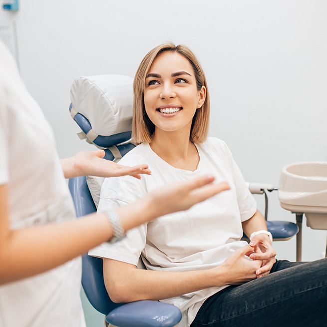 Woman in dental chair smiling at dentist