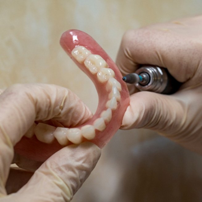 Lab technician filing teeth