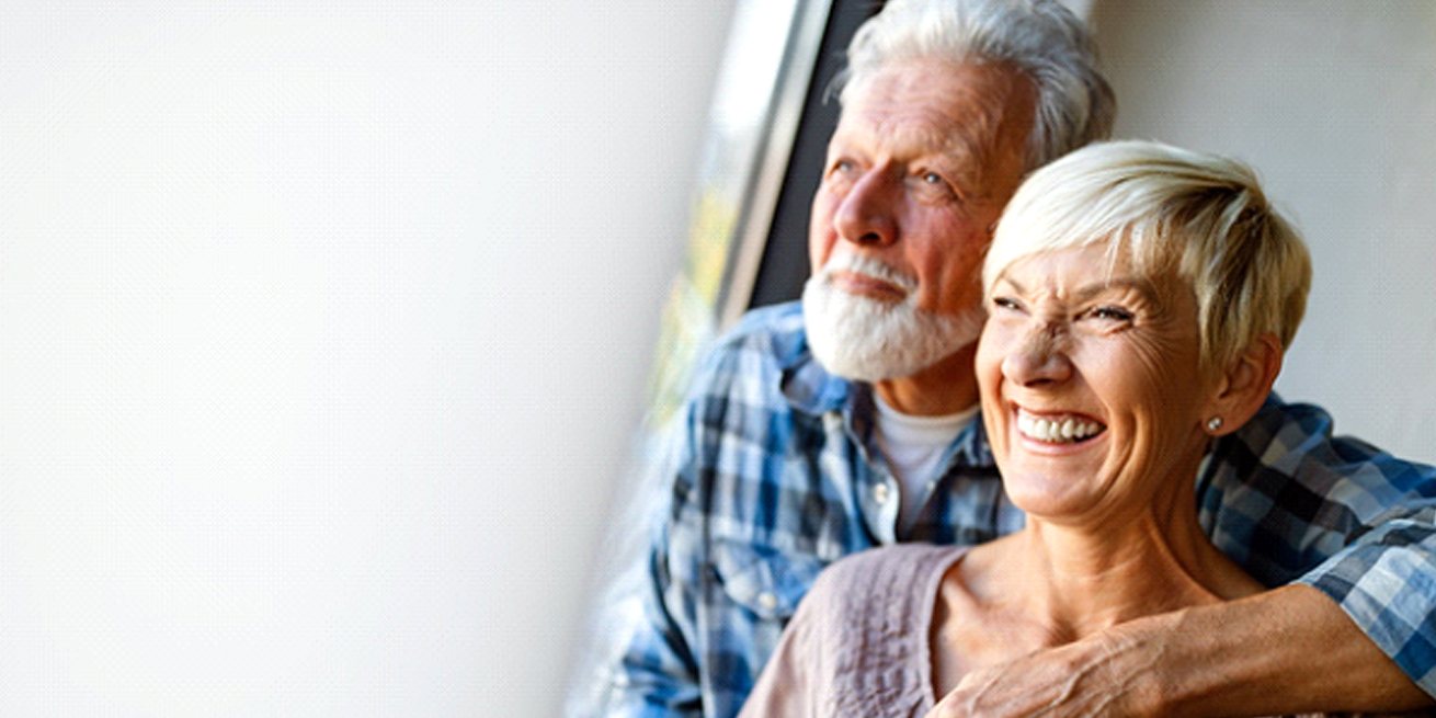 couple hugging and smiling with dentures in Burien