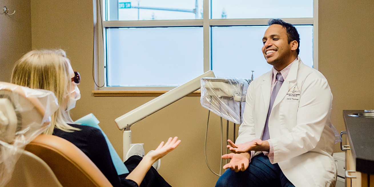 Doctor Thomas talking to dental patient