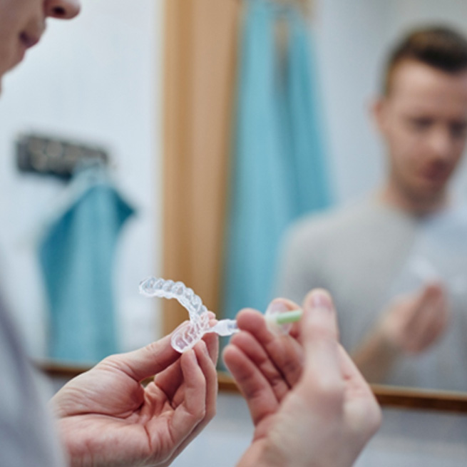 Man using an at-home teeth whitening kit 