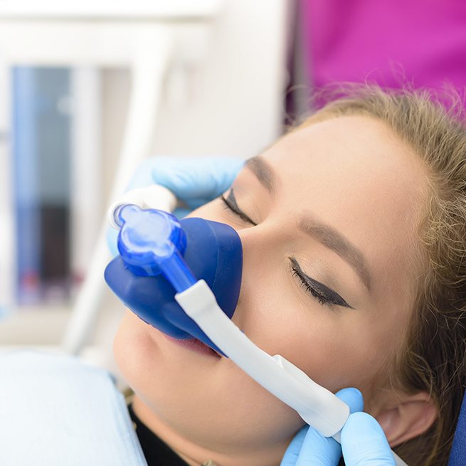 Woman with nitrous oxide dental sedation mask during treatment