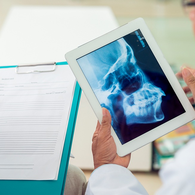 Dentist using x-rays to diagnose and treat T M J dysfunction