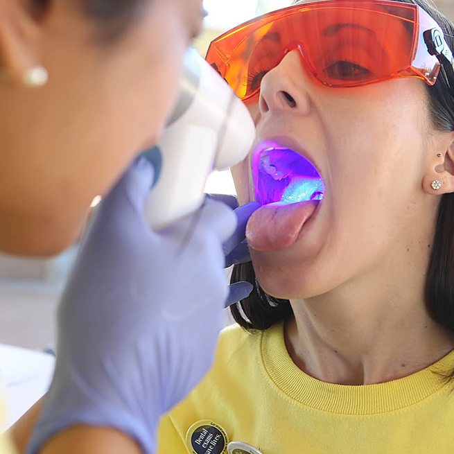 Dentist performing oral cancer screening