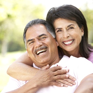 couple smiling and enjoying the long-term benefits of dental implants in Burien