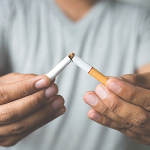 A person breaking a cigarette in half to stop a bad habit in Burien