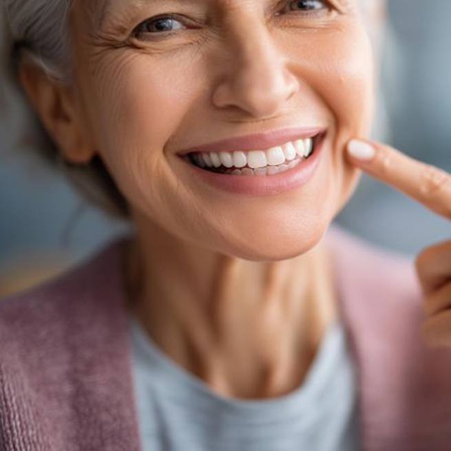 Happy mature woman pointing at her smile