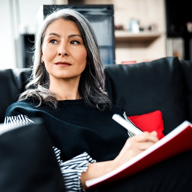 A middle-aged woman contemplating tooth replacement after meeting with a dental implant dentist in Burien