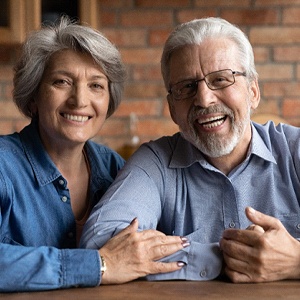 An older couple smiling after receiving dental implants in Burien