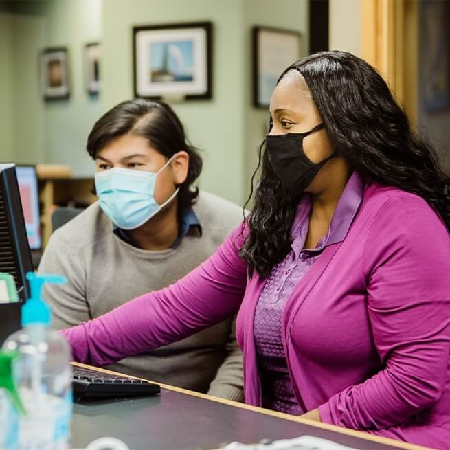 Two Burien dental team members looking at computer screen