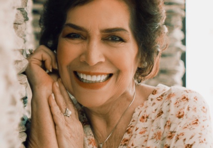 Older woman in flowery blouse grinning