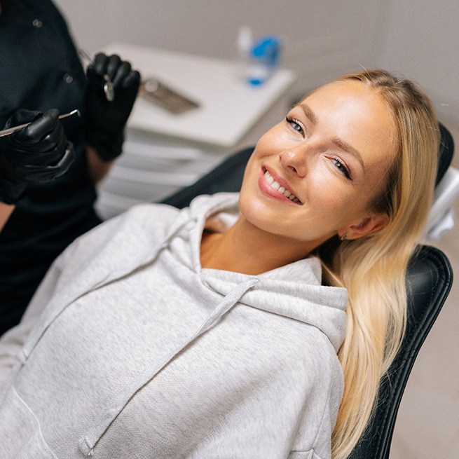 Patient reclined in treatment chair smiling