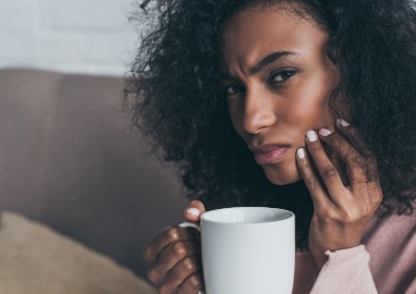 Woman in need of emergency dentistry holding jaw in pain