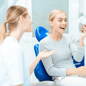 a patient checking her veneers after paying the cost