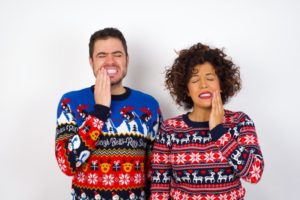 couple in holiday sweaters who didn’t protect their smiles 