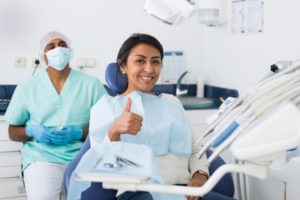 woman giving the thumbs up after acing her dental exam