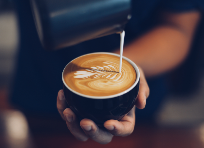 Milk being poured in coffee to create latte art