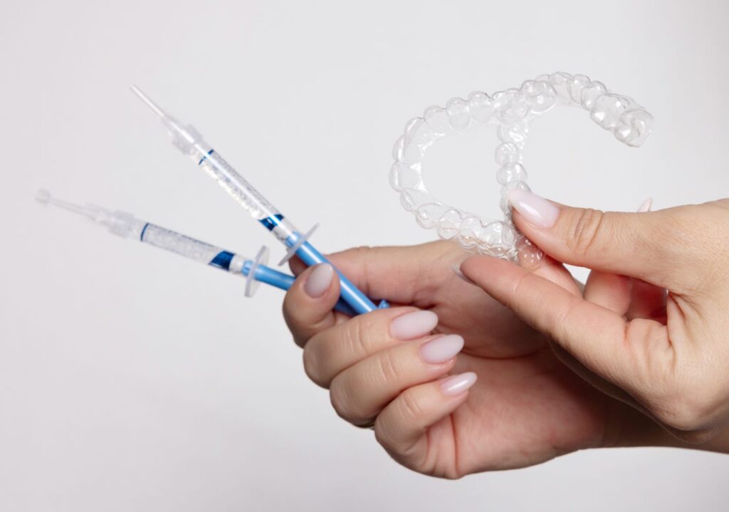 A woman holding a professional teeth whitening kit.